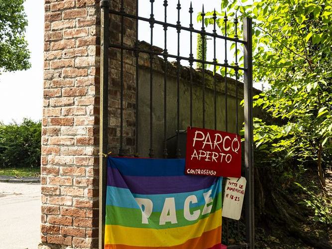 Il pilastro del cancello di Villa Casnati con il cartello Parco Aperto e la bandiera della pace
