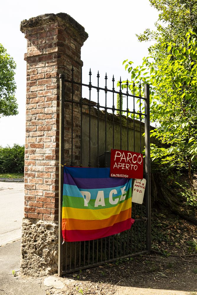 Il pilastro del cancello di Villa Casnati con il cartello Parco Aperto e la bandiera della pace
