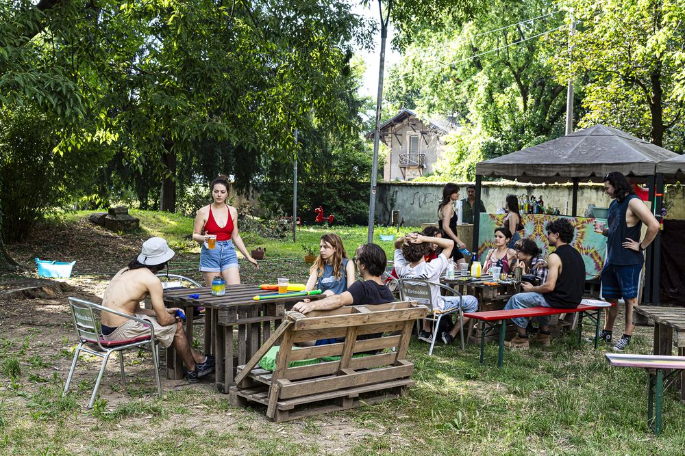 Pubblico seduto sul prato sotto gli alberi durante il concerto di Livore e Utopia Filez