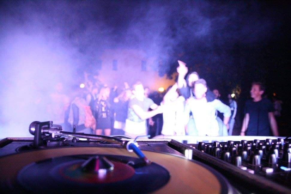Consolle e vinili a ParcOne con il pubblico illuminato
