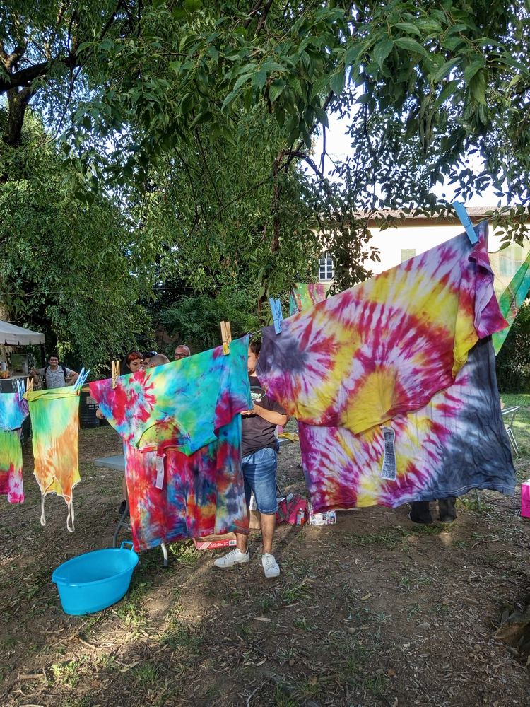 Teli tie-dye colorati stesi ad asciugare nel parco